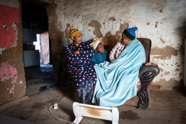 DE AAR, EMTHANJENI - 28 August 2021 - A family in a township near De Aar keep warm with a blanket and electric heater.Photo: Bram Lammers